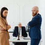 stressed couple standing in front of a divorce lawyer