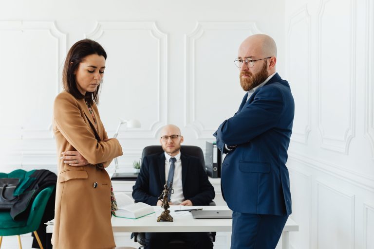 stressed couple standing in front of a divorce lawyer